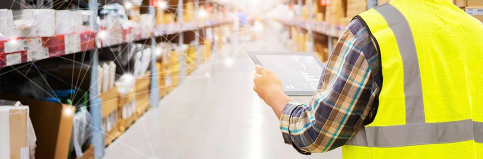 A worker holding a tablet in a warehouse
